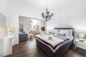 um quarto com uma cama grande e um lustre em IPM Apartments em Kaštela