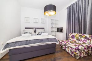 a bedroom with a bed and a chair at IPM Apartments Kaštela, parking, pool, 10 minutes from Split airport in Kaštela