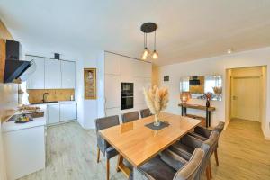 a kitchen and dining room with a wooden table and chairs at IPM Apartments in Kaštela