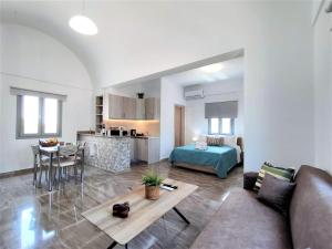 una sala de estar con un sofá y una mesa en Studio Elpida Santorini, en Vóthon