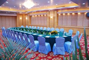 a banquet hall with a long table and blue chairs at Zhuhai Dehan Hotel in Zhuhai