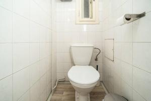 ein weißes WC in einem weiß gefliesten Bad in der Unterkunft Compact Apartment Sleeps 6 + Great Location in Prag