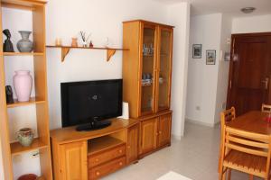 ein Wohnzimmer mit einem TV auf einem hölzernen Entertainment-Center in der Unterkunft VV El Médano Sur in El Médano