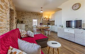 ein Wohnzimmer mit einem roten Sofa und einer Küche in der Unterkunft 2 Bedroom Cozy Home In Filipana in Filipana