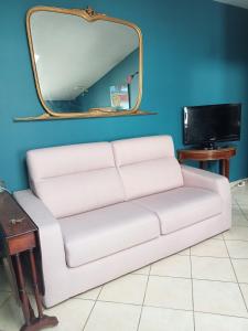 un divano bianco in una stanza con specchio di il rifugio di d'annunzio a Montesilvano