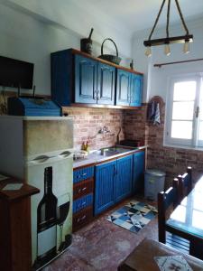 a kitchen with blue cabinets and a sink at Teo & Niki in Paleokastritsa
