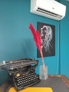 una piuma rossa in un vaso accanto a una vecchia macchina da scrivere di il rifugio di d'annunzio a Montesilvano