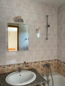 a bathroom with a sink and a tub and a mirror at Prostor Apartments in Obzor