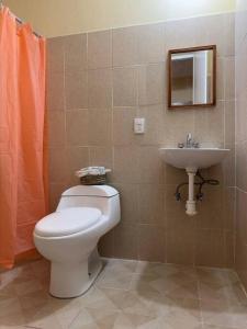 a bathroom with a toilet and a sink at Departamento completo, cómodo y cerca del aeropuerto in San Agustin de las Juntas