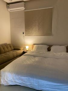 um quarto com uma cama branca e um sofá em شقة مدخل خاص دخول ذاتي em Riyadh
