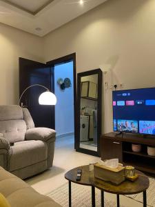 uma sala de estar com um sofá e uma televisão de ecrã plano em شقة مدخل خاص دخول ذاتي em Riyadh
