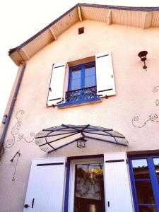 a building with a window and an umbrella at Le jardin Renard-Clos sur Loir cottage in the Loir & Loire valleys in La Chapelle-aux-Choux +55 photos