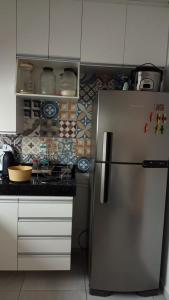 a kitchen with a stainless steel refrigerator and white cabinets at Casa Duplex - Garanhuns in Garanhuns