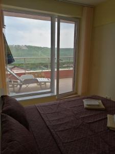 a bedroom with a bed and a window with a balcony at The Seaview jacuzzi Suite complex Karia in Kavarna +52 photos