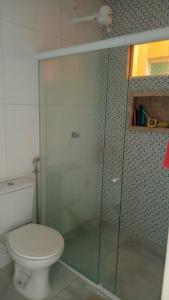 a bathroom with a toilet and a glass shower at Casa Duplex - Garanhuns in Garanhuns