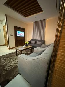 a living room with a couch and a table at Leen Serviced Apartments in Khamis Mushayt