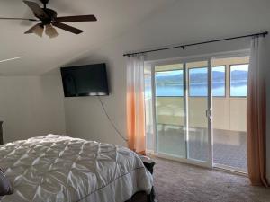 a bedroom with a bed and a flat screen tv at Amazing Lakefront Home with a Private Beach in Lake Elsinore