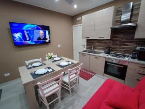 kuchnia ze stołem i telewizorem na ścianie w obiekcie BOLANO HOUSE w Katanii