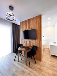 a living room with a table and chairs and a television at TideHaven in Palanga