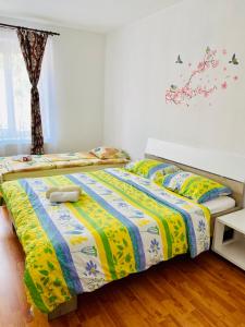 a bedroom with two beds with yellow and blue sheets at Casa Victoria in Cârțișoara