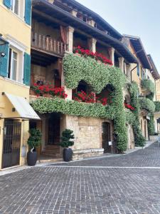 a building with flowers on the side of it at Tiny House in the center in Torri del Benaco