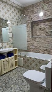 La salle de bains est pourvue de toilettes, d'un lavabo et d'une baignoire. dans l'établissement luxury apartments, à Assilah