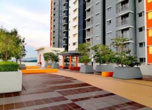 a courtyard with potted trees in front of buildings at Alanis Suite KLIA With Neflix & Airport Shuttle in Sepang