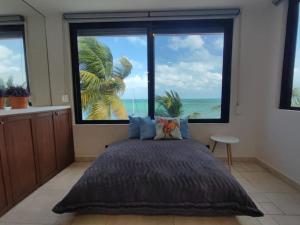 1 dormitorio con ventana grande con vistas al océano en Puerta al mar, en Cancún