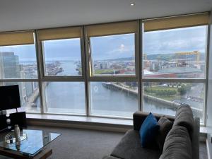 a living room with a large window view of a river at Titanic and Sea View Belfast 2 bedroom Apartment City Centre in Belfast