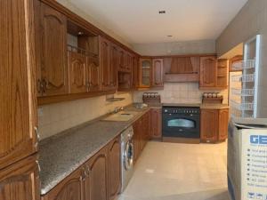 a kitchen with wooden cabinets and a stove top oven at Charming Apartment in Shmeisani in Amman