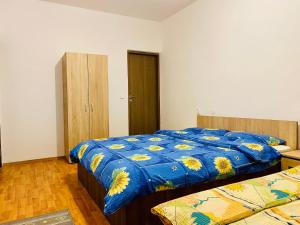 a bedroom with two beds with a blue comforter at Casa Victoria in Cîrţişoara