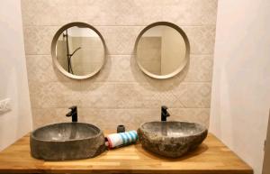 La salle de bains est pourvue de 2 lavabos et de 2 miroirs. dans l'établissement Appartement 72m2 cosy centre ville, à Saint-Rémy-de-Provence
