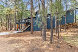 una casa azul en el bosque con árboles en Chic Design, Hottub, MtnView, Quiet cul-de-sac, en Flagstaff
