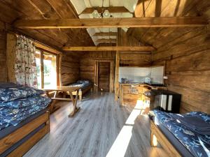 pokój z 2 łóżkami i stołem w kabinie w obiekcie Domki wędkarskie nad Stawami Pirania w mieście Zagórz