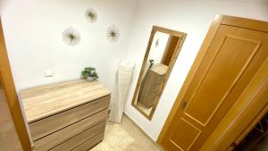 a bathroom with a mirror and a wooden door at Amplio apartamento en centro in Denia +20 photos