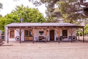 une maison avec une table et des chaises devant elle dans l'établissement Compass View, à Nieu-Bethesda