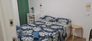 une chambre avec un lit avec une couverture bleue et blanche dans l'établissement LA MARINA, à Alicante