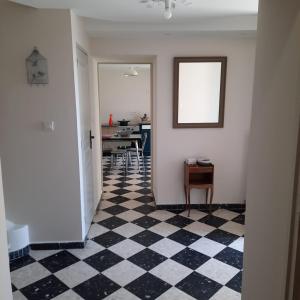 a hallway with a black and white checkered floor at Maison provençale rénovée in Pernes-les-Fontaines