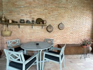 ペルージャにあるLe Balze Appartamentiのレンガの壁の前にテーブルと椅子
