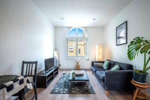 a living room with a couch and a tv at Cosy flat in Central LDN Payment to the HOST in London