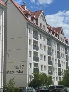 duży biały budynek z czerwonym dachem w obiekcie Pomorskie Apartamenty Mazurska w Gdańsku