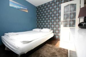1 dormitorio con 1 cama con pared azul en Pomorskie Apartamenty Mazurska, en Gdansk