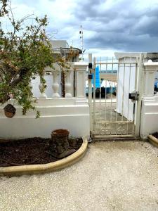 una recinzione bianca con un cancello e un albero di Villa La Torretta Luxury B&B - Adults Only - a Rimini