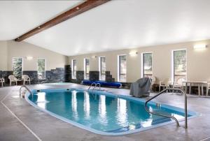 una gran piscina en un edificio con mesas y sillas en EverSpring Inn & Suites en Hill City
