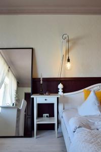 a bedroom with a bed and a table and a mirror at Spicīte in Ventspils