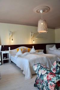 a bedroom with a large white bed and a chair at Spicīte in Ventspils