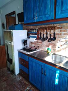 a kitchen with blue cabinets and a white refrigerator at Teo & Niki in Paleokastritsa +43 photos