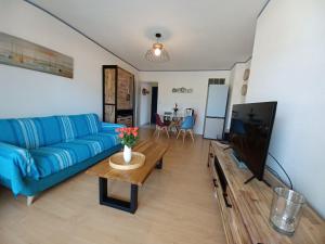 Una sala de estar con un sofá azul y una mesa. en Le Pacha, en Andernos-les-Bains
