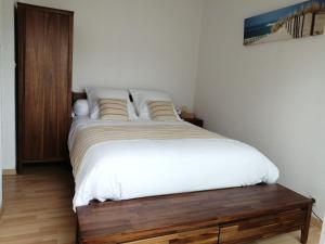 Un dormitorio con una cama grande con sábanas blancas. en Le Pacha, en Andernos-les-Bains