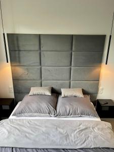 a large bed with a gray headboard in a bedroom at STUDIO ADX24 in Malbork